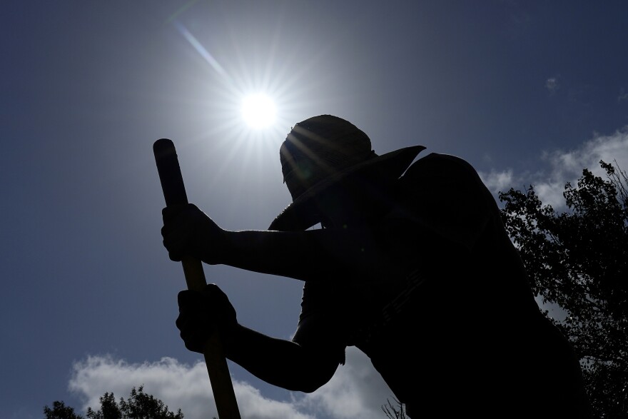 Carlos Rodriguez digs fence post holes Tuesday, June 27, 2023, in Houston. Meteorologists say scorching temperatures brought on by a heat dome have taxed the Texas power grid and threaten to bring record highs to the state. (AP Photo/David J. Phillip)