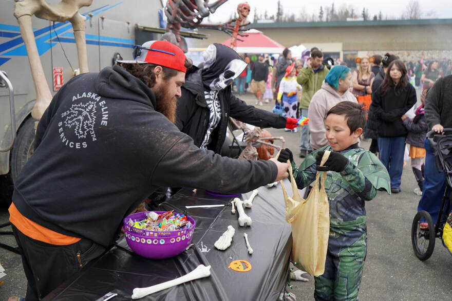 Staff from Alaska E-Line Services fill Master Chief's bag with candy at the Trunk-or-Treat hosted by the Boys and Girls Clubs of the Kenai Peninsula on Saturday, Oct. 24, 2026, in Kenai, Alaska.