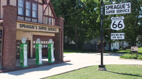 An entrance to Sprague's is seen, with replica gas pumps and a welcome sign.