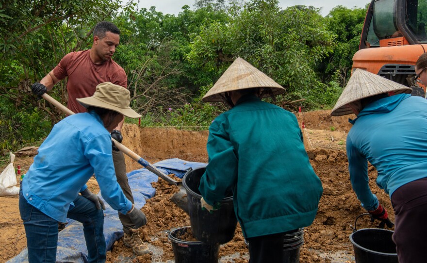 Air Force Master Sgt. Javier Martinez, left, and Vietnamese citizens fill buckets of soil during a Defense POW/MIA Accounting Agency (DPAA) mission in Quang Binh Province, Vietnam, March 29, 2026. The DPAA recovery team was searching for clues to locate the remains of troops missing from the Vietnam War.