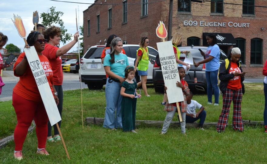  GCAE members hold a large petition with 2,300 signatures 