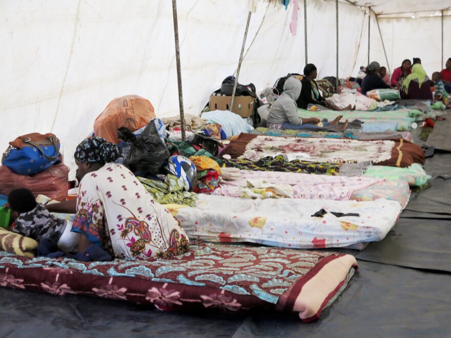 The African workers are living in tents set up on a sports field.