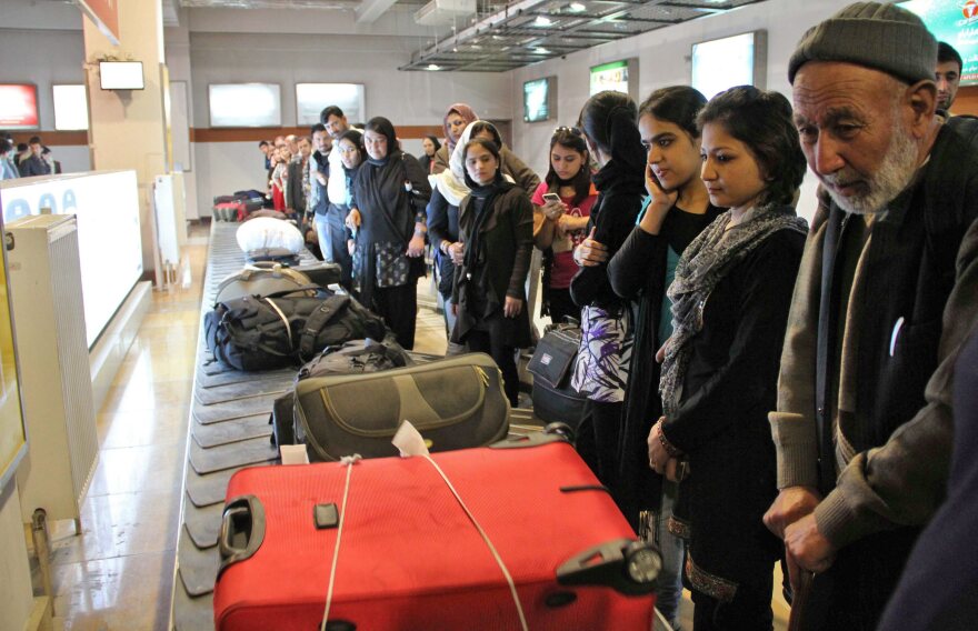 Passengers wait for their luggage at Kabul International Airport in March. Visas are difficult to come by, so many Afghans rely on smugglers to make their way out of the country.