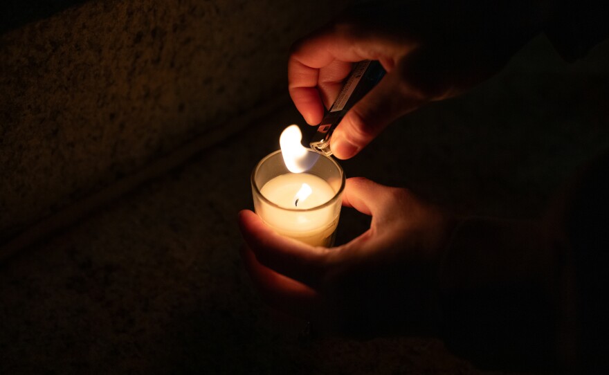 Ryan Loudermilk lights a candle during a vigil for Renee Good and other victims of ICE violence on the steps of the Alton Lennon Federal Building in downtown Wilmington on January 14, 2025. Community members listened as organizers with Siembra NC and elected officials spoke and honored the victims.