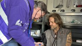 Tim Chandler, a licensed practical nurse who works with the Mental Health Association Oklahoma Street Medicine Outreach team checks Robert Hairell's blood pressure during a visit to a large homeless encampment in Oklahoma City.