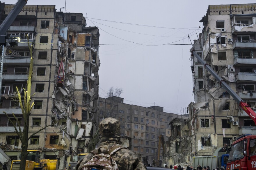 A soldier stares up at a gaping hole in an apartment building in the aftermath of a Russian missile attack in Dnipro in January.