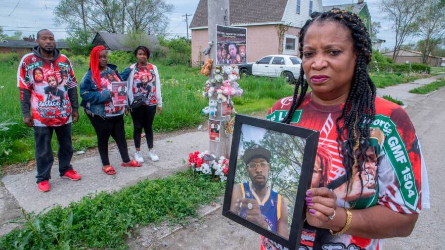 La’Tatia Stewart holds a photo of her son Gregory Stewart. Her children, Paul Stewart Jr. and Therica Dowden stand with Danaysia Stewart her granddaughter and daughter of her son Gregory Stewart.