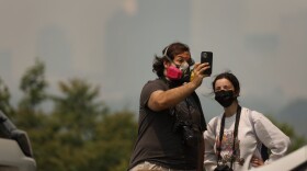 Henry Litsky and Sarah Woodams take a selfie with the Rochester skyline covered in smoke from Cobbs Hill on Wednesday, June 7, 2023. "I would rather be safe than sorry," Woodams said when asked why she chose to wear a mask outdoors. The New York State Department of Environmental Conservation on Wednesday classified the Rochester region's air quality as "unhealthy" due to the smoke from raging wildfires in Canada.