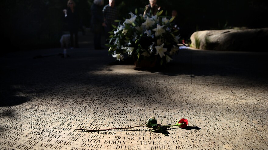 A flower lays on the engraved names of AIDS victims at the National AIDS Memorial Grove on December 1, 2015 in San Francisco, Calif.