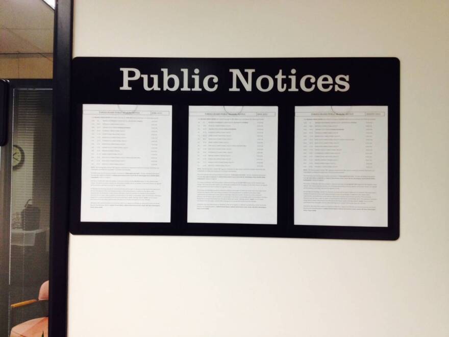 A posting of public meetings outside an office at the Indiana Government Building South