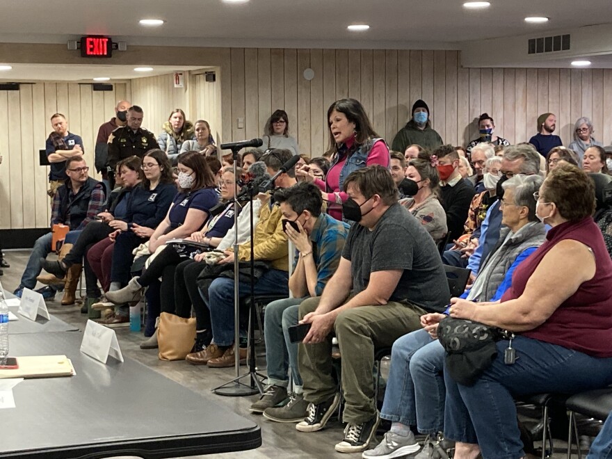 A woman speaks at a microphone during the Floyd County Library board of trustees meeting Monday. Also pictured are many of the more than 100 people also in attendance. 