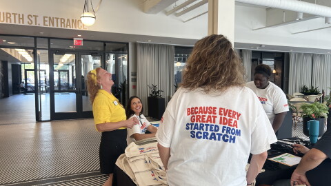 Staff and volunteers laugh together at the From Scratch Food Summit check in