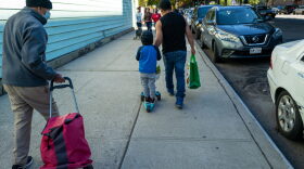 A child joins his father as residents receive food at the St. Helena Pantry in the Bronx in New York City.