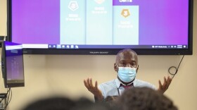 Daile Cox reviews math vocabulary with students at School of the Arts. He ties math terms to real life experiences to get students invested.