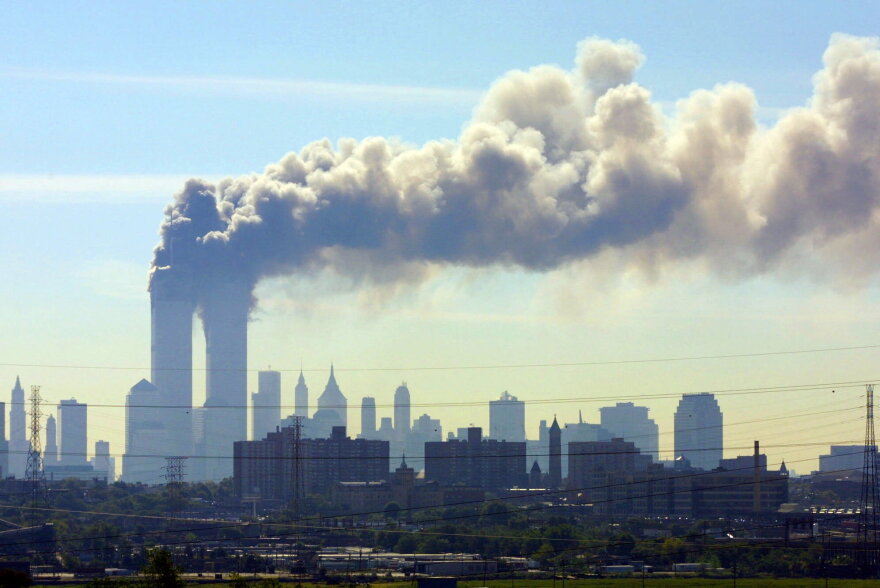 FILE - In this Sept. 11, 2001 file photo, as seen from the New Jersey Turnpike near Kearny, N.J., smoke billows from the twin towers of the World Trade Center in New York after airplanes crashed into both towers. (AP Photo/Gene Boyars)
