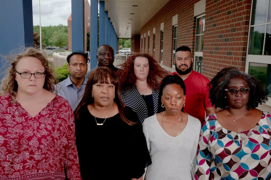 Parents and leaders stand at the Suffield High School. About 40 parents and residents created a group and meet once a week to discuss goals and actions plans to create policy changes to help eradicate racism in the school system.