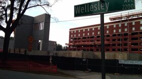 The new red brick parking garage topped with two floors of student housing sits beyond the athletic center seen in the