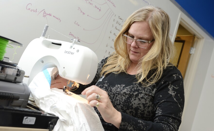 Baltimore bridal dress designer Jill Andrews says gowns and protective suits are a lot alike: tricky to put on — and take off.