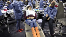Donna Smith, center, laughs with Dr. Brad McPhee before getting a filling during the Seattle/King County Clinic on Thursday, October 26, 2017, at Key Arena. Smith drove from Vancouver, Washington, and waited in line starting at 10 p.m. on Wednesday night.