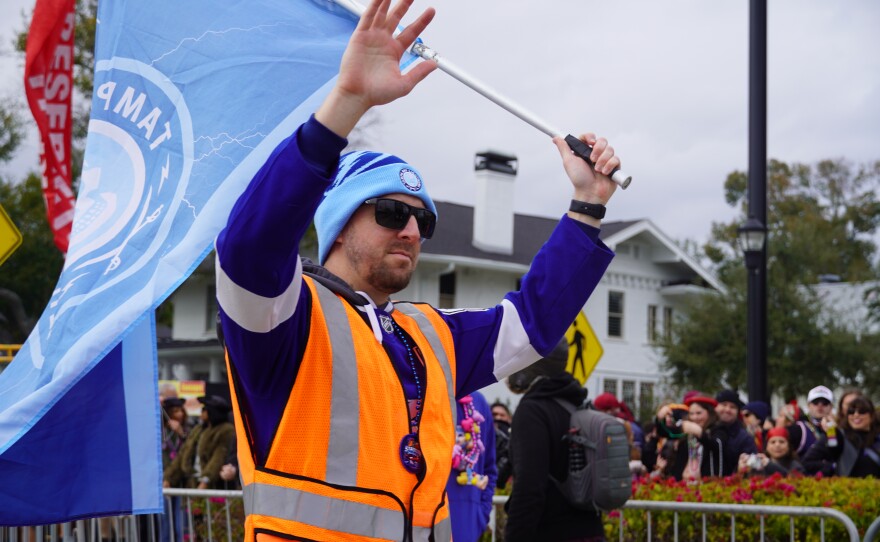 Man waves flag down parade 