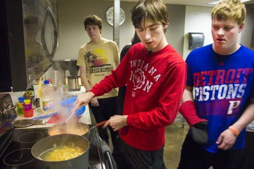 Reagan Roush, center, makes a creamy chicken fajita pasta dish at a weekly cooking skills class at the College Internship Program in Bloomington, Indiana.