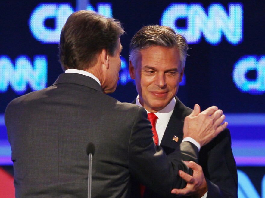 <p>Former Utah Gov. Jon Huntsman (right) and Texas Gov. Rick Perry confer during a break in the Sept. 12 presidential debate in Tampa. Huntsman first objected to Perry's use of the word "treasonous" then later used it himself. </p>