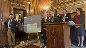 Wisconsin Republican Rep. Nate Gustafson holds a tape measure in front of fellow Republicans to demonstrate how far he was drawn out of his legislative district under a map proposed by Democratic Gov. Tony Evers during a Capitol news conference Wednesday, Jan. 24, 2024, in Madison, Wis. Republicans proposed a bill making changes to the Evers map.