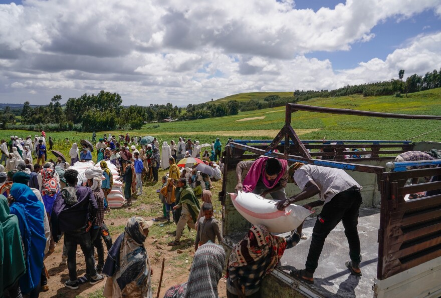 Volunteers unload food aid in Chena, Ethiopia, one of many parts of the world where conflict has fueled hunger.