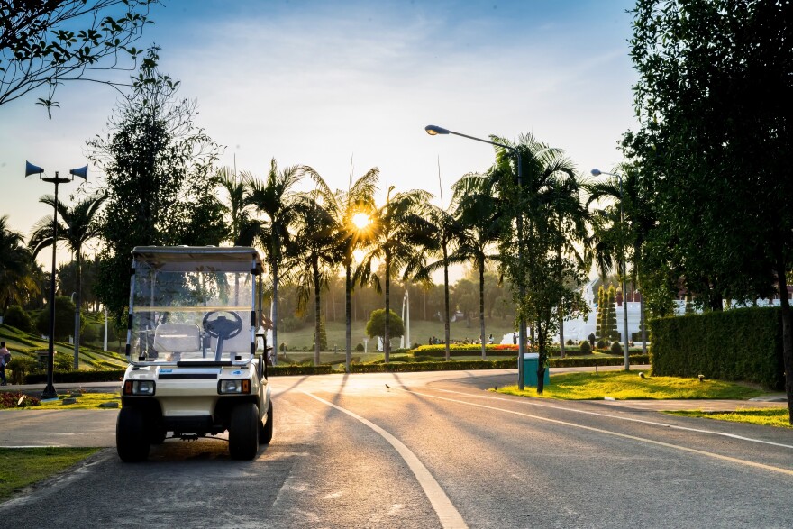 golf cart parked on a neighborhood street at sunset