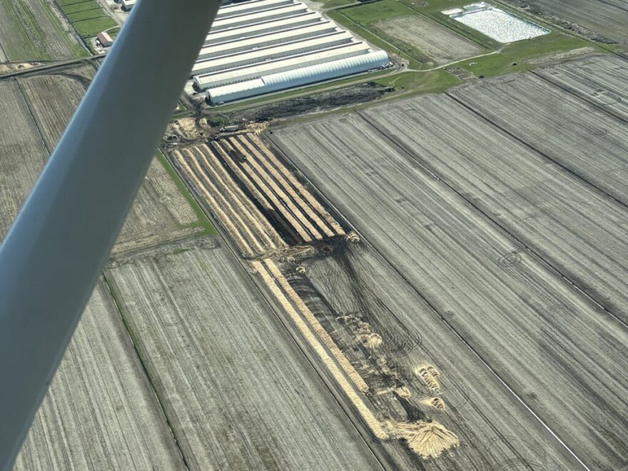 Lines of litter, combined with a darker mound, indicate ongoing cleanup.