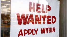 A sign that reads "Help Wanted Apply Within" is seen hanging in a window of a beverage store. (Tim Boyle/Getty Images)