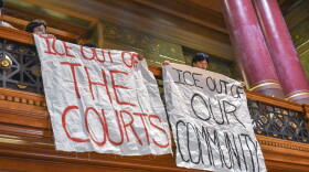 Protestors unfurl banners within the Province City Council Chamber on at the start of the Committee on Ordinance’s meeting Oct. 6, 2025. The vast majority of the more than 50 people who spoke at the meeting were against police cooperation with immigration officers.