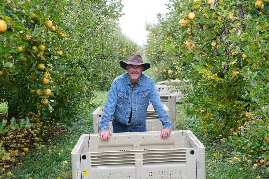 Mike Meyer, Head of Advocacy at The Farmlink Project, poses in front of bins the non-profit donated for transportation.