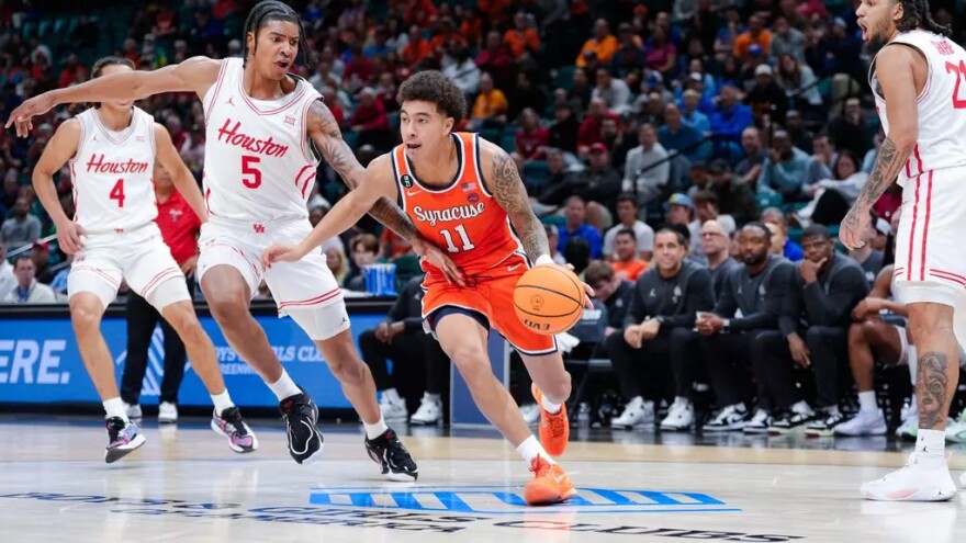 Orange guard Naithan George (11, Orange) dribbles through a host of Cougar defenders.