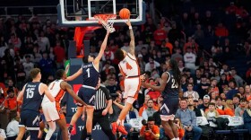 Syracuse guard Nate Kingz (4, White) finishes a layup beyond the reach of Monmouth forward Jason Rivera-Torres. (1, Navy)