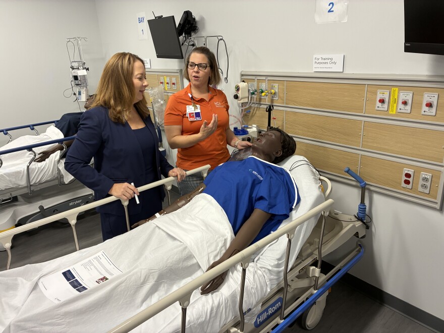 Erin Keister, chief nurse executive for HCA's Capital Division (left), speaks with clinical educator Leah Wagner over a mannequin patient at LewisGale Regional Health System's new clinical simulation center. 