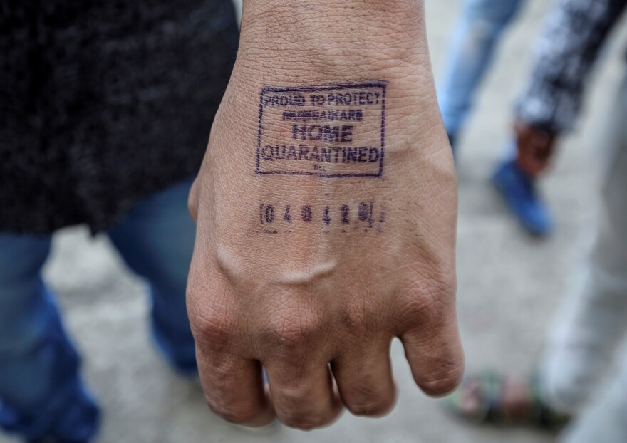 Airport authorities are stamping the hands of people arriving in the country to show how long they need to stay in quarantine at their home.