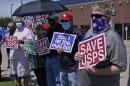 Ken Mayfield, right, National Association of Letter Carriers Oklahoma City Branch president, holds a sign during a news conference in front of a USPS post office Tuesday, Aug. 18, 2020, in Oklahoma City.