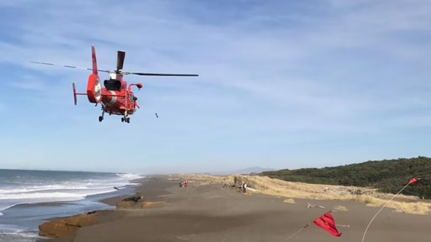 FILE - In this photo provided by the Oregon State Police taken Sunday, Jan. 15, 2017, a U.S. Coast Guard helicopter searches a beach about two miles north of Cape Blanco, Oregon.