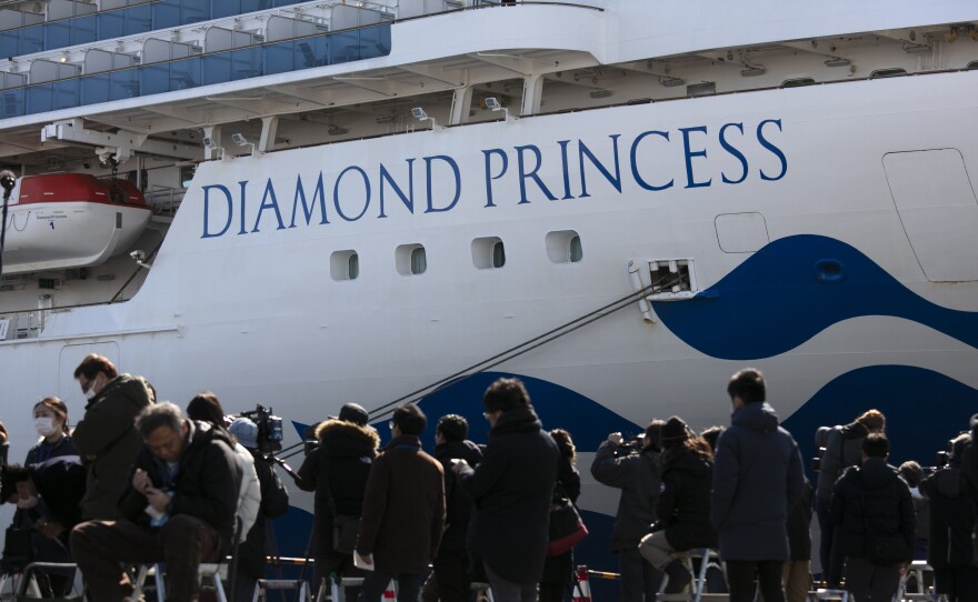 Media gather outside the quarantined Diamond Princess cruise ship in Yokohama, near Tokyo, on Tuesday. Japan's Health Ministry announced 65 new confirmed cases of the deadly coronavirus on the ship.