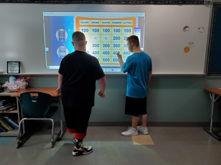 Ellet High School Students Blaine Smith and Kyle Bolinger play an educational game on a smart board. 