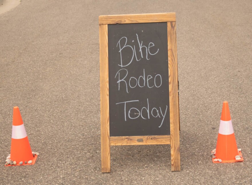 A sign in the parking lot of the Cadillac Farmers Market. The cones near the sign have been decorated with rocks by the rodeo's young guests.