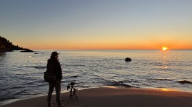 Bugsy Sailor watches the sunrise on October 16, 2025 at Little Presque Isle in Marquette County, Michigan. (credit: Dan Wanschura / Points North)
