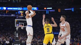 New York Knicks' Josh Hart, left, shoots over Indiana Pacers' T.J. McConnell, center, as Knicks' Isaiah Hartenstein, right, watches during the first half of Game 1 in an NBA basketball second-round playoff series Monday, May 6, 2024, in New York. (AP Photo/Frank Franklin II)