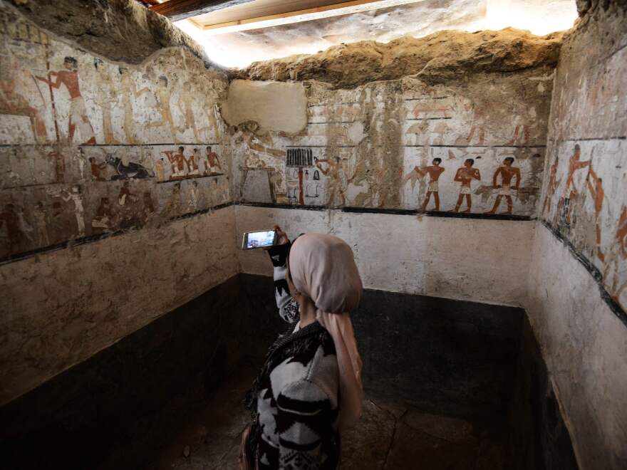 A woman takes a photo inside the tomb of an Old Kingdom priestess that was unveiled on Saturday after being discovered during excavation work in Giza's western cemetery by a team of Egyptian archaeologists.