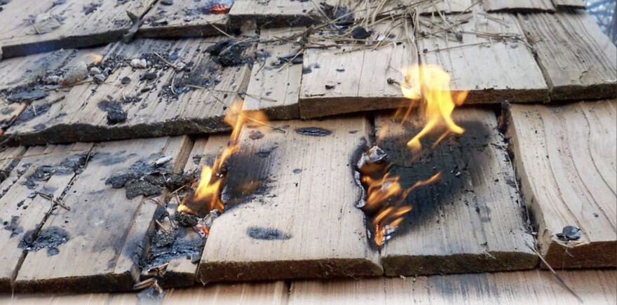 Flames burn the wooden roof of a home in the western U.S.