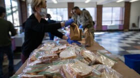 Volunteer Rhiannon Navin and U.S. National Guard troops put together meals for distribution to local residents at the WestCop community center on March 18, 2020 in New Rochelle, New York. New Rochelle has been a hot spot for the COVID-19 pandemic in the U.S. (John Moore/Getty Images)