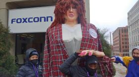 Protestors interact with a large puppet meant to portray GOP gubernatorial candidate Rebecca Kleefisch, during a protest Monday outside a Foxconn sign in downtown Milwaukee.