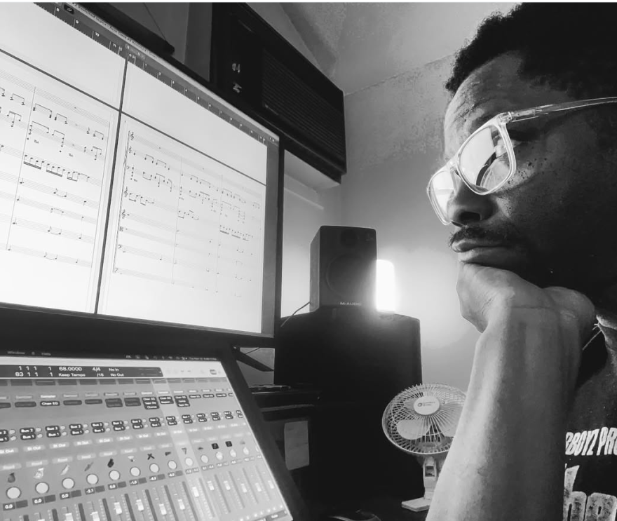 Eriq Troi shows his songwriting process by composing songs on a computer