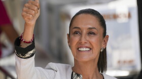 A close up of a woman giving thumbs up.